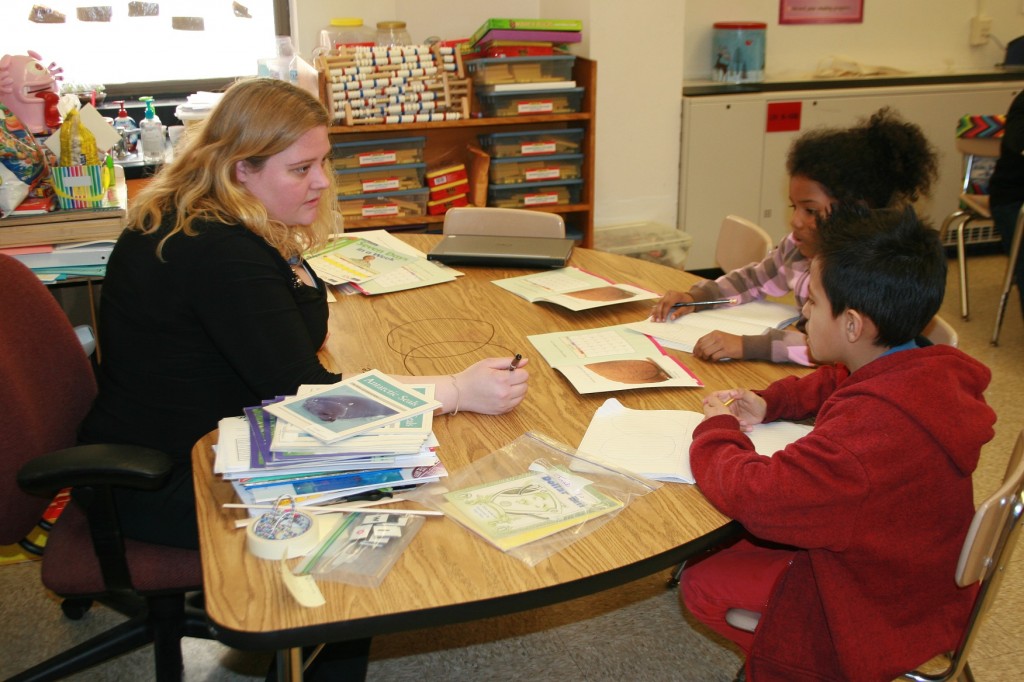Second grade teacher Ashley Thornton conducts a small group reading session, teaching Common Core standards, with Aaliyah and Jose at Gaithersburg Elementary School.