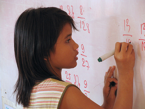 girl at white board math class school (by mrcharly on Flickr)