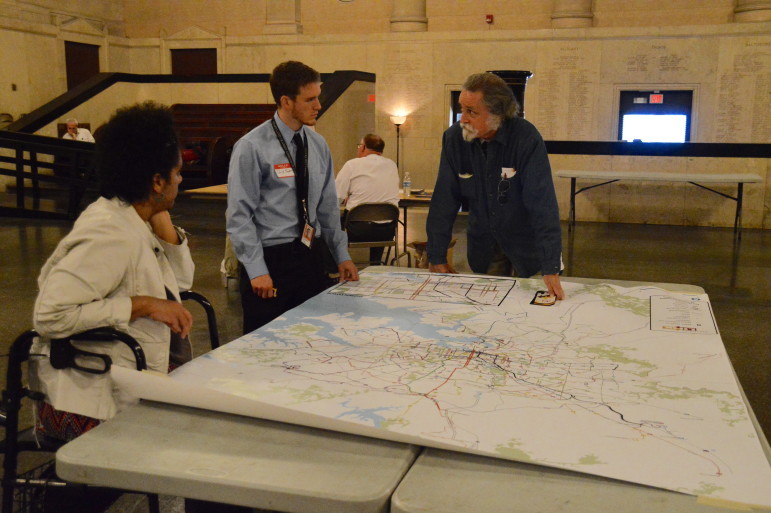 Martin French (far right) talks with Maryland Transit Administration employee Chris Snyder (middle) about bus routes at the first BaltimoreLink workshop at Baltimore’s War Memorial on Nov. 4, 2015. French said that the existing bus routes are congested and need to be improved so that people can get to work on time. (Capital News Service photo by Brittany Britto)