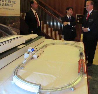 Del. Bob Long of Dundalk discusses the maglev train project with Japanese representatives next to a model of the high-speed train at the home of Japan's ambassador. 