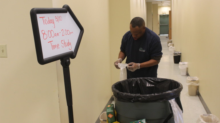 Brian Beckham, a custodial worker with disabilities at Melwood, finishes tying up the final trash bag during a demonstration of the now-obsolete time trials  in the Melwood center. Capital News Service photo by Josh Magness.