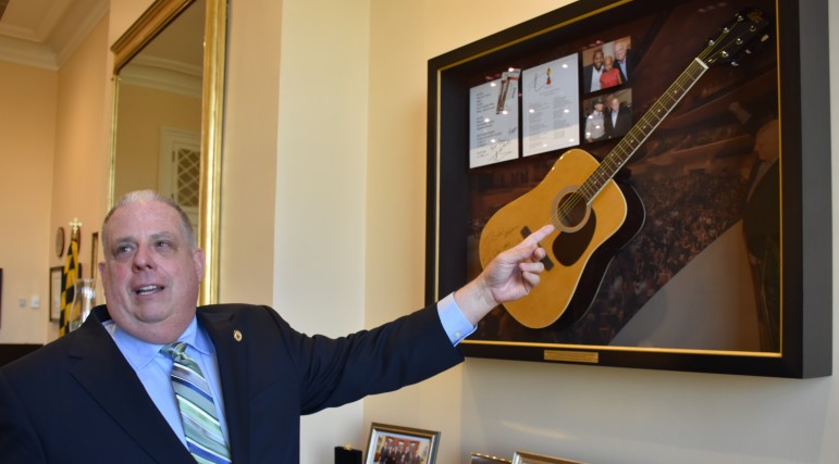 Gov. Larry Hogan explains the Tim McGraw guitar hanging on the wall of his office. Photo by Rachel Bluth, Capital News Service