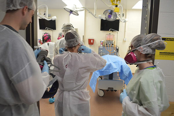 Students from The Community College of Baltimore County crowd around two donated bodies at the University of Maryland School of Medicine, April 5, 2016. They wear protective face gear to protect themselves from formaldehyde that can cause upper respiratory problems. 